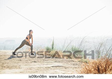 Woman doing stretching exercise on hilltop View Large Photo Image Picture - Woman doing stretching exercise on hilltop. Fotosearch