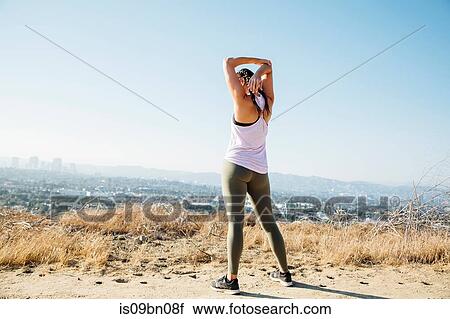 Woman doing stretching exercise on hilltop, Los Angeles, US View Large Photo Image Stock Image - Woman doing stretching exercise on hilltop, Los Angeles, US. Fotosearch