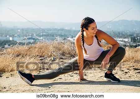 Woman doing stretching exercise on hilltop, Los Angeles, US View Large Photo Image Stock Image - Woman doing stretching exercise on hilltop, Los Angeles, US. Fotosearch