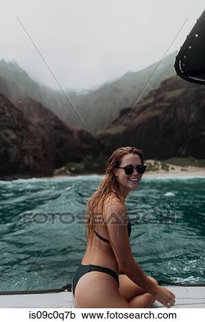 Stock Image - Woman enjoying boat ride, Princeville, Hawaii, US. Fotosearch