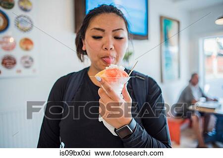 Woman enjoying ice cream in hostel, Maui, Hawaii View Large Photo Image Stock Image - Woman enjoying ice cream in hostel, Maui, Hawaii. Fotosearch