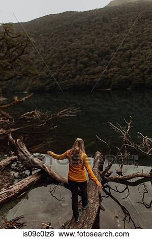 Stock Photo - Woman enjoying scenic lake view, Queenstown, Canterbury, New Zealand. Fotosearch