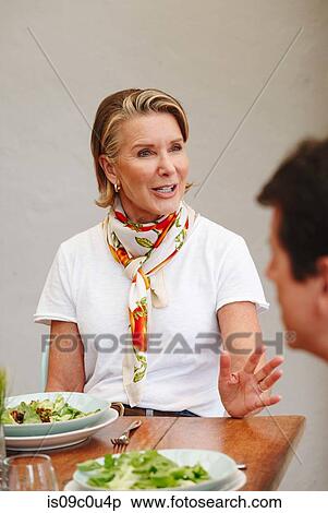 Stock Photography - Woman having lunch with friend in restaurant. Fotosearch