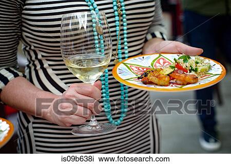 Woman holding glass of wine and plate of food, mid section View Large Photo Image Stock Image - Woman holding glass of wine and plate of food, mid section. Fotosearch