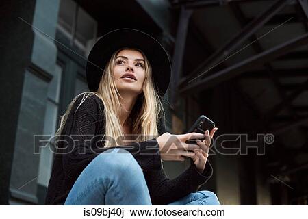 Woman holding mobile phone looking away, New York, USA View Large Photo Image Stock Image - Woman holding mobile phone looking away, New York, USA. Fotosearch