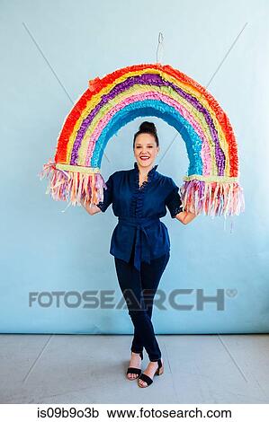 Woman holding rainbow pinata View Large Photo Image Stock Image - Woman holding rainbow pinata. Fotosearch