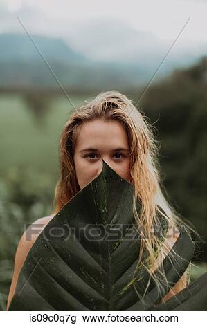 Woman in bikini holding large leaf, Princeville, Hawaii, US View Large Photo Image Stock Image - Woman in bikini holding large leaf, Princeville, Hawaii, US. Fotosearch