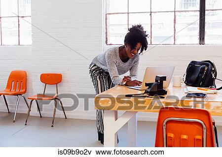 Woman in industrial office building using laptop View Large Photo Image Stock Photo - Woman in industrial office building using laptop. Fotosearch