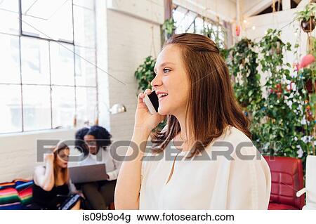 Woman in office making telephone call on smartphone View Large Photo Image Stock Image - Woman in office making telephone call on smartphone. Fotosearch