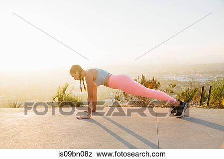 Woman in plank position on hilltop View Large Photo Image Stock Photo - Woman in plank position on hilltop. Fotosearch