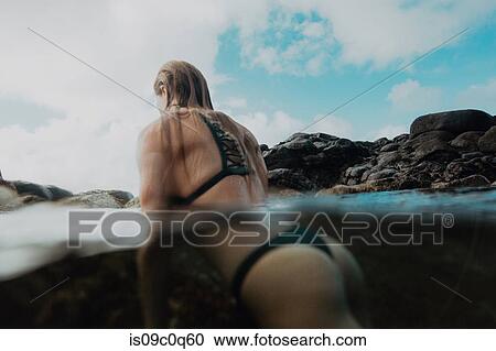 Woman in sea by rocks, Princeville, Hawaii, US View Large Photo Image Stock Image - Woman in sea by rocks, Princeville, Hawaii, US. Fotosearch