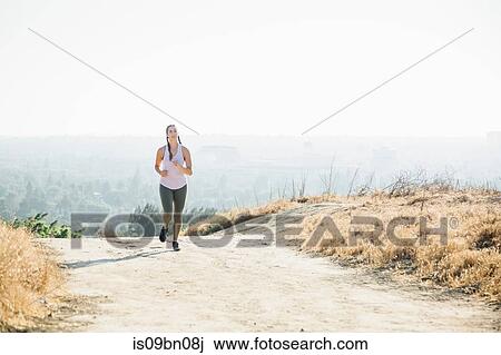 Woman jogging on hilltop View Large Photo Image Stock Image - Woman jogging on hilltop. Fotosearch