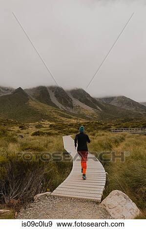 Stock Photo - Woman jogging on trail path, Wanaka, Taranaki, New Zealand. Fotosearch