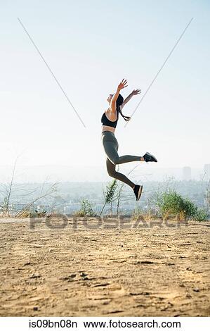 Woman jumping into air on hilltop View Large Photo Image Picture - Woman jumping into air on hilltop. Fotosearch