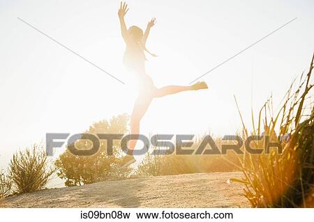 Woman jumping into air on hilltop View Large Photo Image Stock Photo - Woman jumping into air on hilltop. Fotosearch
