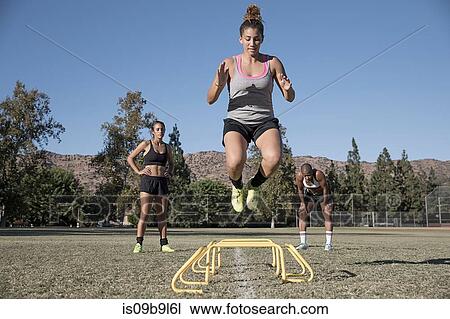 Woman jumping over agility hurdles View Large Photo Image Stock Image - Woman jumping over agility hurdles. Fotosearch
