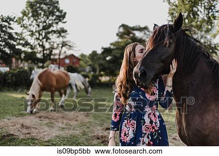 Stock Image - Woman kissing horse. Fotosearch