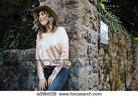 Woman leaning on old stone wall in park, San Rafael, California, US View Large Photo Image Stock Photo - Woman leaning on old stone wall in park, San Rafael, California, US. Fotosearch