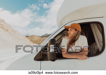 Picture - Woman leaning out window of motorhome. Fotosearch