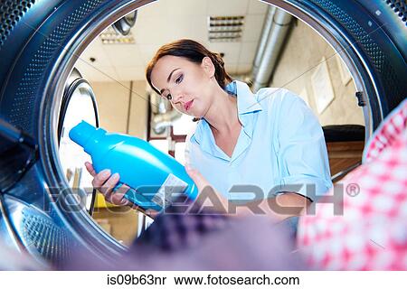 Woman looking at fabric conditioner for washing machine laundry at laundrette View Large Photo Image Stock Photography - Woman looking at fabric conditioner for washing machine laundry at laundrette. Fotosearch