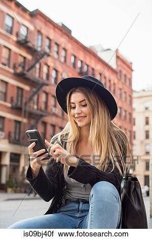 Woman looking at mobile phone smiling, texting, New York, USA View Large Photo Image Stock Image - Woman looking at mobile phone smiling, texting, New York, USA. Fotosearch
