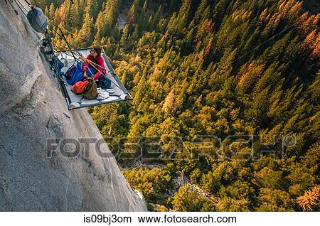 Woman looking up from portaledge on triple direct, El Capitan, high angle view, Yosemite Valley, California, USA View Large Photo Image Picture - Woman looking up from portaledge on triple direct, El Capitan, high angle view, Yosemite Valley, California, USA. Fotosearch