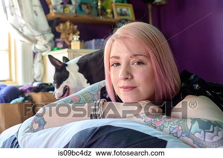 Woman lying on bed with pet dog View Large Photo Image Stock Photo - Woman lying on bed with pet dog. Fotosearch