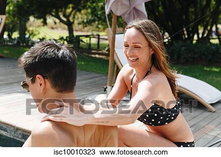 Woman massaging man's shoulder by swimming pool View Large Photo Image Stock Image - Woman massaging man's shoulder by swimming pool. Fotosearch