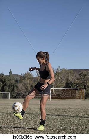 Woman on football pitch playing football View Large Photo Image Stock Image - Woman on football pitch playing football. Fotosearch