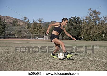 Woman on football pitch playing football View Large Photo Image Stock Image - Woman on football pitch playing football. Fotosearch