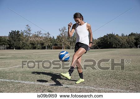 Woman on football pitch playing football View Large Photo Image Stock Photo - Woman on football pitch playing football. Fotosearch