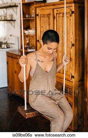 Woman on indoor swing View Large Photo Image Stock Photograph - Woman on indoor swing. Fotosearch