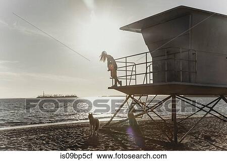 Woman on lifeguard tower, sunset in background View Large Photo Image Stock Image - Woman on lifeguard tower, sunset in background. Fotosearch