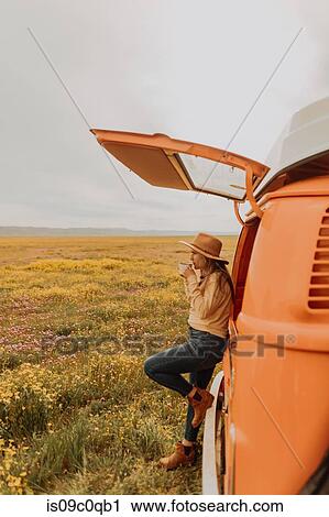 Stock Image - Woman on road trip in countryside. Fotosearch