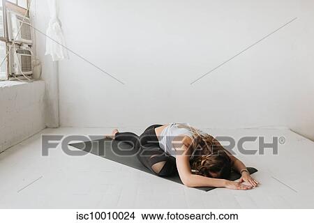 Picture - Woman practising yoga in studio. Fotosearch
