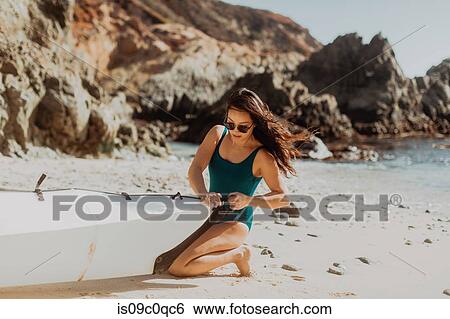 Stock Photograph - Woman preparing kayak on beach, Big Sur, California, United States. Fotosearch