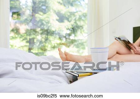 Woman, relaxing on bed, reading book, low section, books and coffee cup in foreground View Large Photo Image Stock Photography - Woman, relaxing on bed, reading book, low section, books and coffee cup in foreground. Fotosearch