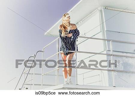 Stock Image - Woman relaxing on lifeguard tower. Fotosearch