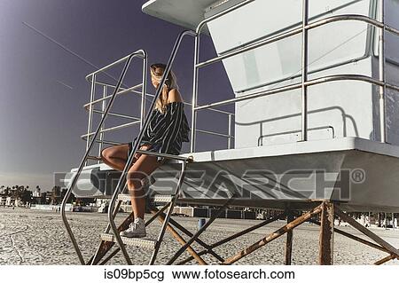 Woman relaxing on lifeguard tower View Large Photo Image Stock Image - Woman relaxing on lifeguard tower. Fotosearch