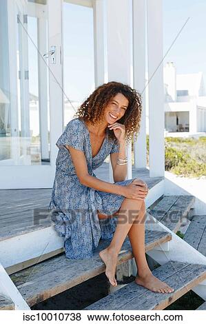 Woman relaxing on steps in front of beach house View Large Photo Image Stock Photo - Woman relaxing on steps in front of beach house. Fotosearch