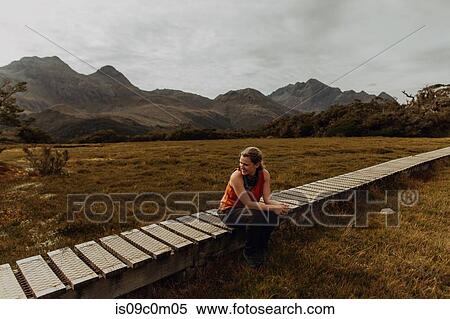 Stock Photography - Woman relaxing on trail path, Queenstown, Canterbury, New Zealand. Fotosearch
