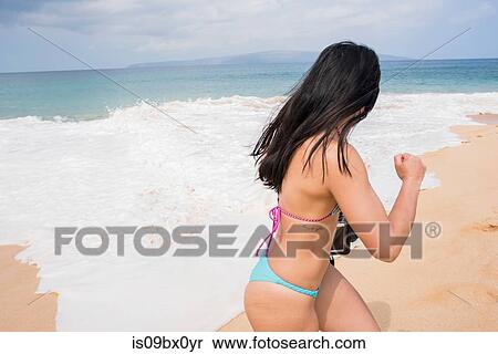 Woman running away from sea waves, Makena Beach, Maui, Hawaii View Large Photo Image Stock Photography - Woman running away from sea waves, Makena Beach, Maui, Hawaii. Fotosearch