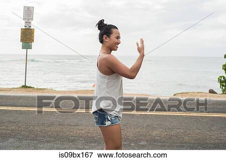 Woman signalling on road by beach, Haleiwa, Oahu, Hawaii View Large Photo Image Stock Photo - Woman signalling on road by beach, Haleiwa, Oahu, Hawaii. Fotosearch