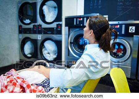 Woman sitting in laundrette staring View Large Photo Image Stock Photo - Woman sitting in laundrette staring. Fotosearch
