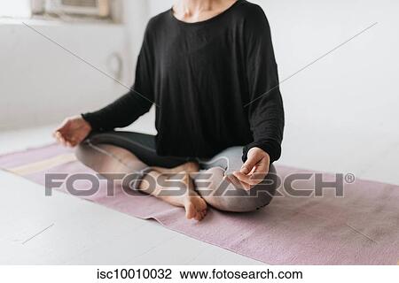 Woman sitting in lotus pose in yoga studio View Large Photo Image Stock Image - Woman sitting in lotus pose in yoga studio. Fotosearch
