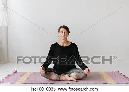Woman sitting in lotus pose in yoga studio View Large Photo Image Stock Photography - Woman sitting in lotus pose in yoga studio. Fotosearch