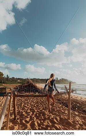 Woman sitting on wooden structure on sandy beach, Princeville, Hawaii, US View Large Photo Image Stock Image - Woman sitting on wooden structure on sandy beach, Princeville, Hawaii, US. Fotosearch