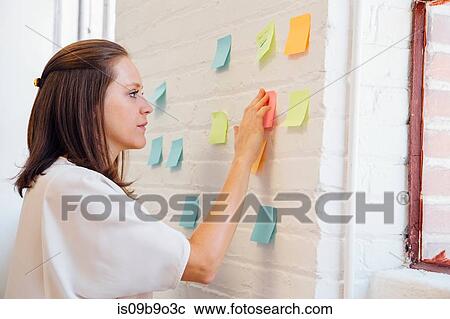 Woman sticking sticky notes to brick wall View Large Photo Image Stock Image - Woman sticking sticky notes to brick wall. Fotosearch