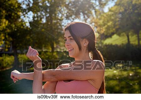 Woman stretching in city park View Large Photo Image Stock Image - Woman stretching in city park. Fotosearch