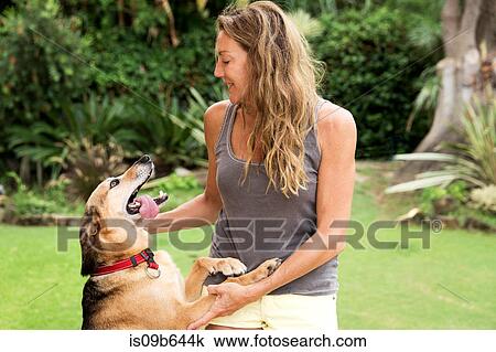 Woman stroking excited dog View Large Photo Image Stock Image - Woman stroking excited dog. Fotosearch
